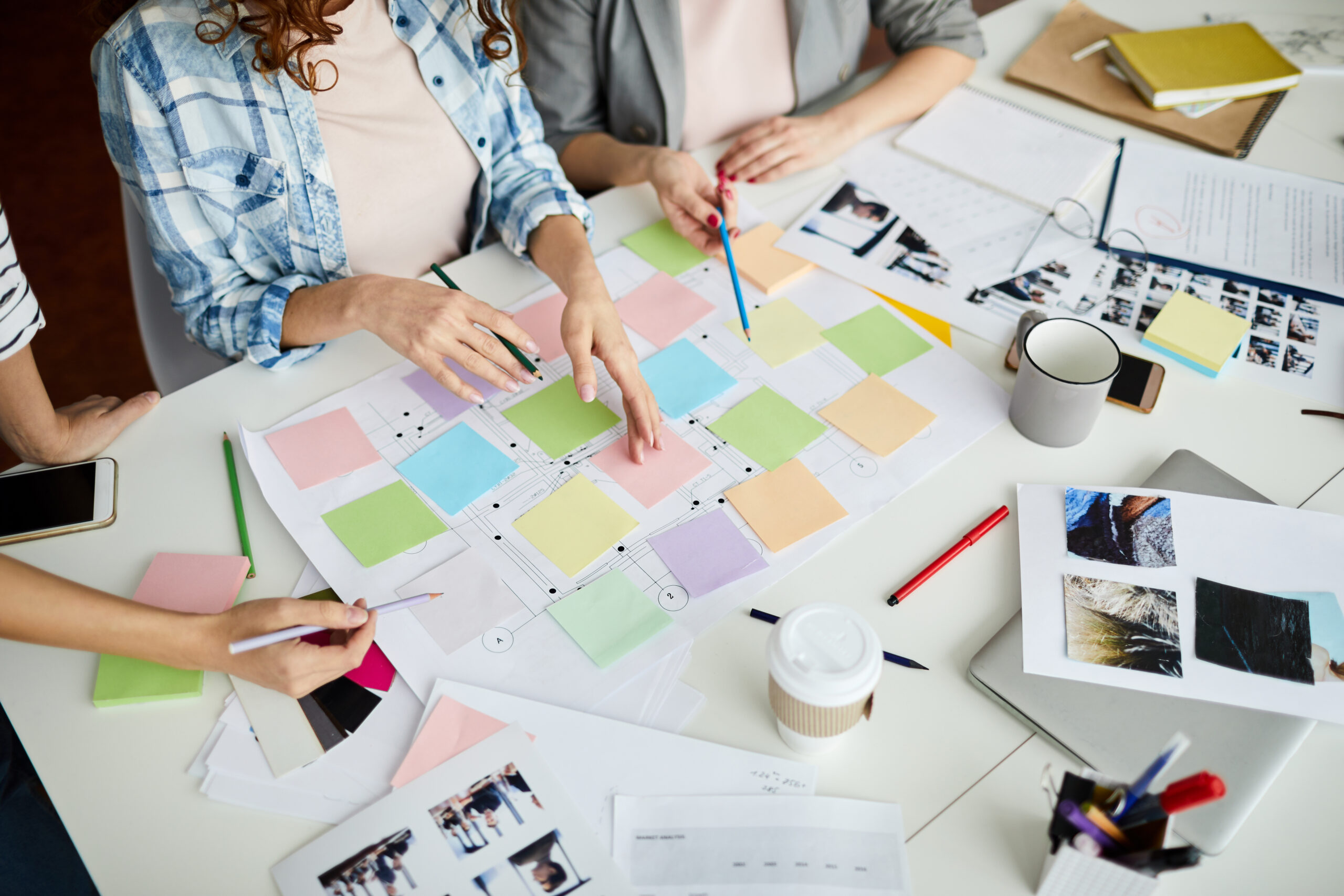 High angle closeup of contemporary business team planning project placing colorful stickers on roadmap, copy space